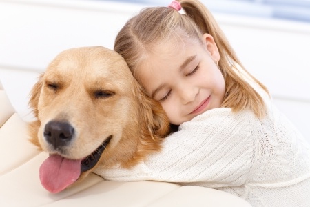 Girl hugging golden retriever